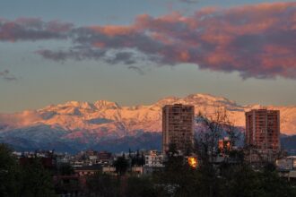 snowy mountain range, city, sunset